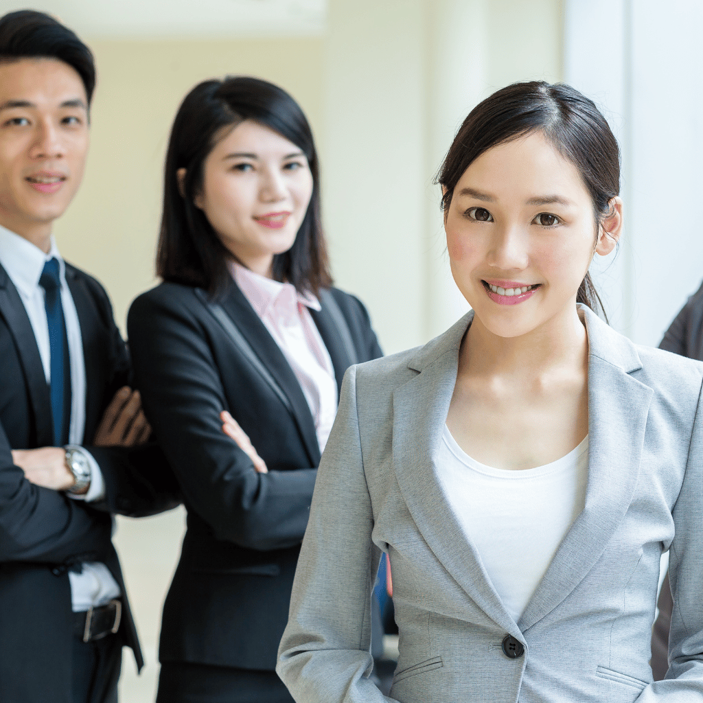 A group of migration and investment link staffs in business attire standing with arms crossed, symbolizing reliability in real estate services.