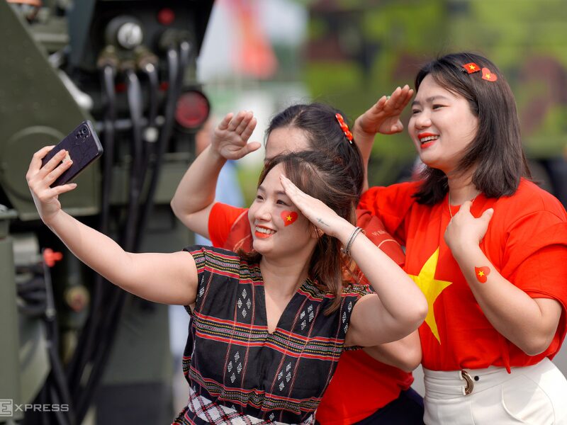 Vietnam National Day Gift celebration with women taking selfie in patriotic attire during parade