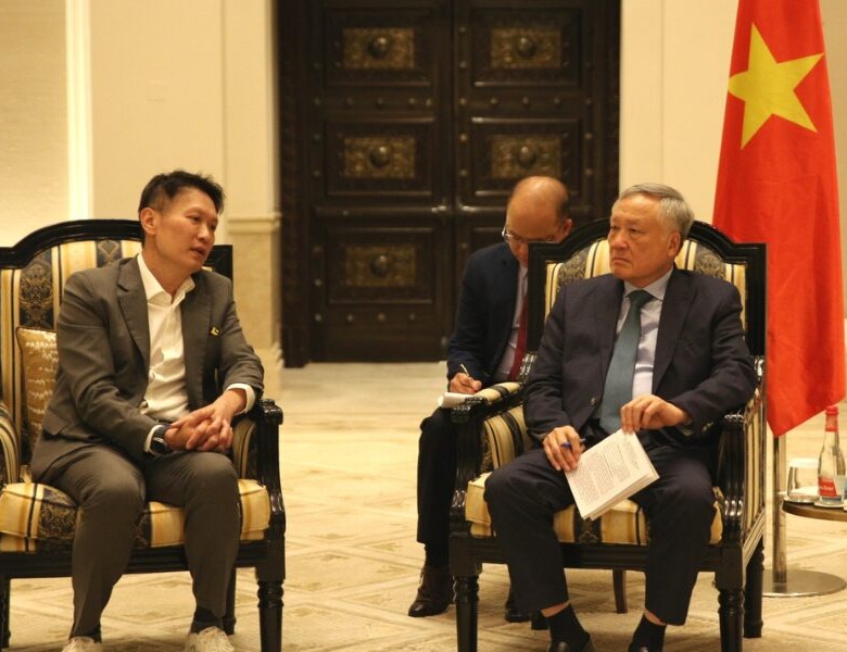 Binance Vietnam executives discussing Da Nang hub plans in elegant meeting room with Vietnamese flags, focus on Binance Vietnam expansion strategy.