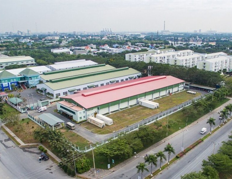 Aerial view of modern Vietnam industrial real estate complex featuring warehouses, factories, and green spaces in an urban industrial zone.