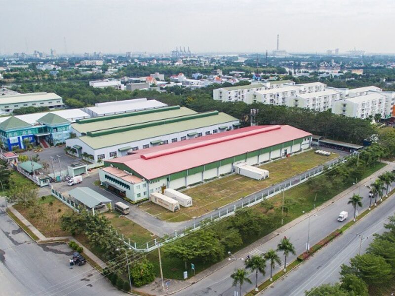 Aerial view of modern Vietnam industrial real estate complex featuring warehouses, factories, and green spaces in an urban industrial zone.