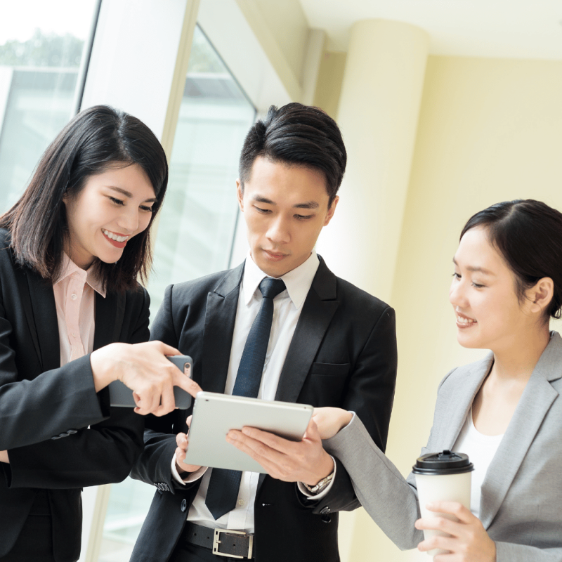 Business team collaborating with a tablet in a modern office for migration application processing.
